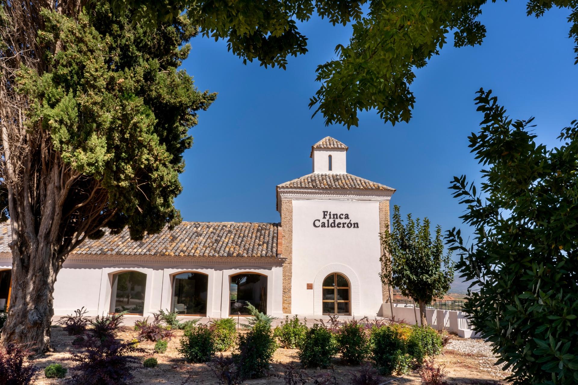Vista frontal del edificio rehabilitado de Finca Calderón Enoresort, destacando su arquitectura del siglo XIX y su entorno natural en Requena.