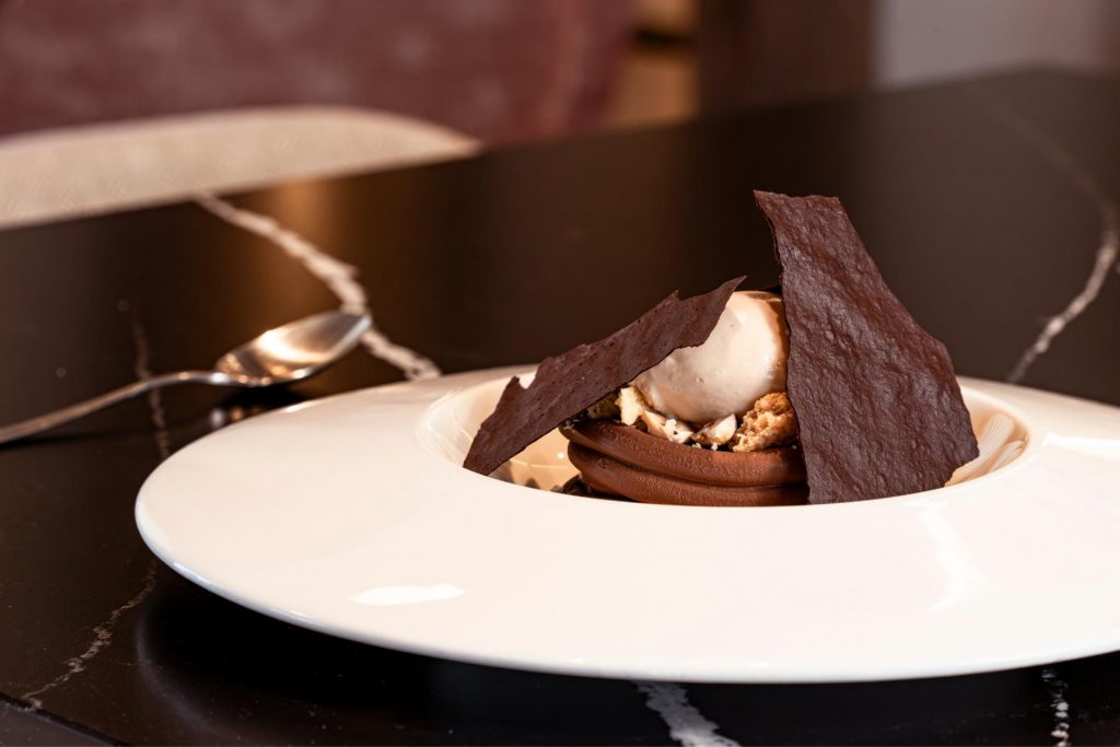 Postre de cremoso de chocolate con caramelo salado y helado de avellana en el restaurante Finca Calderón, una experiencia dulce y gourmet en Requena.