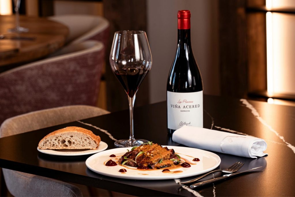 Plato principal de carne del menú gourmet maridado con vino Viña Acered Las Pizarras Garnacha en el restaurante de la bodega Finca Calderón en Requena