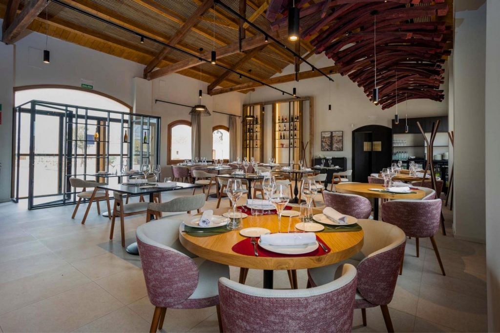 Sala del restaurante Finca Calderón con mesas entre viñedos, ofreciendo una experiencia gastronómica única en Requena.