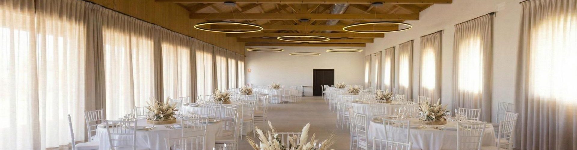 Amplio salón para celebraciones en Finca Calderón Enoresort, con mesas decoradas para bodas y eventos, techos de madera y vistas al viñedo.