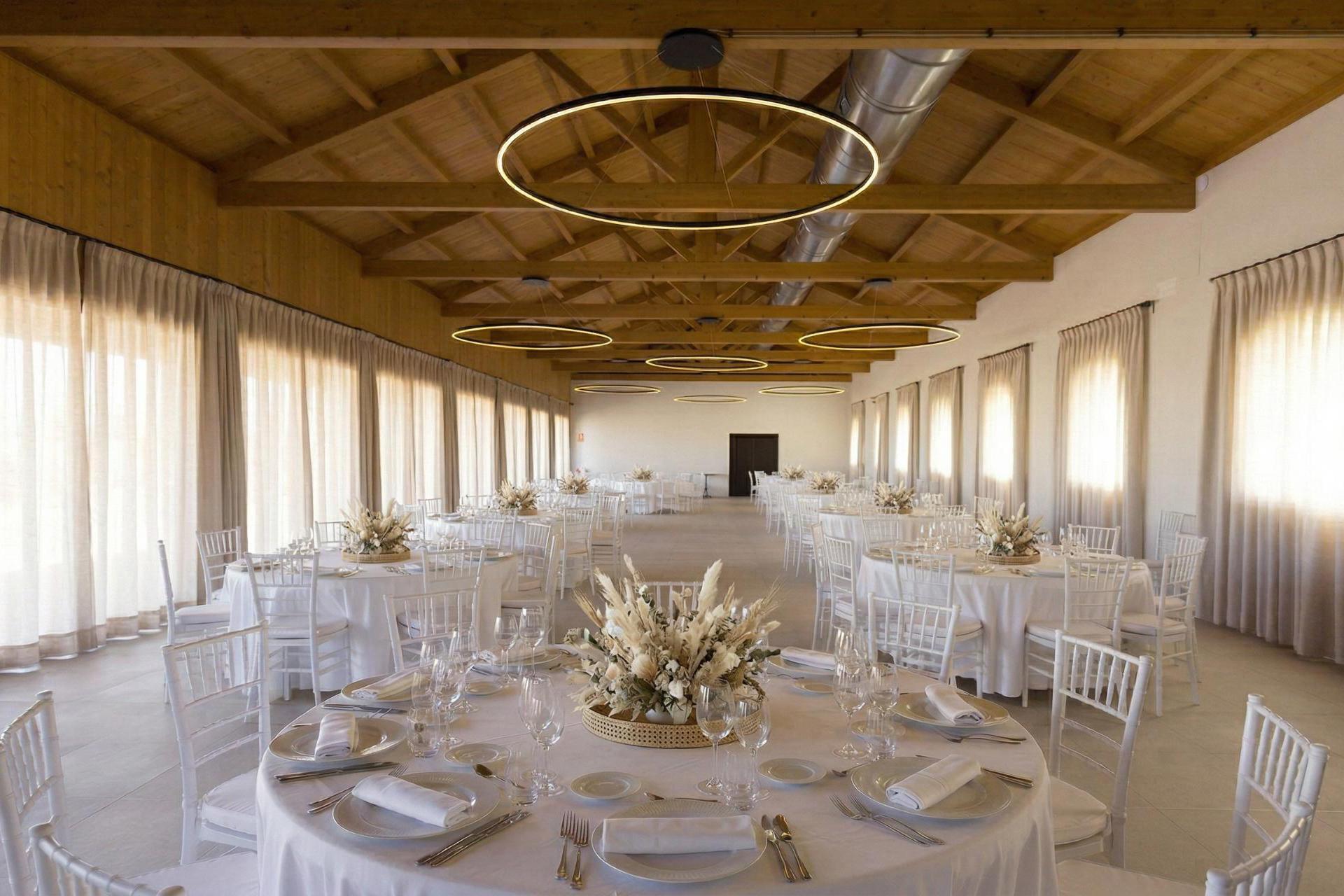 Amplio salón para celebraciones en Finca Calderón Enoresort, con mesas decoradas para bodas y eventos, techos de madera y vistas al viñedo.