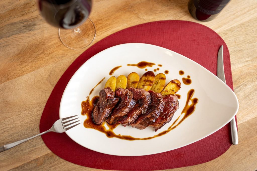 Solomillo de vaca a la brasa con patatas a la manteca negra y vino Bercial Ladera Los Cantos Equilibrio Monastrell, del menú gourmet del restaurante de la bodega Finca Calderón en Requena