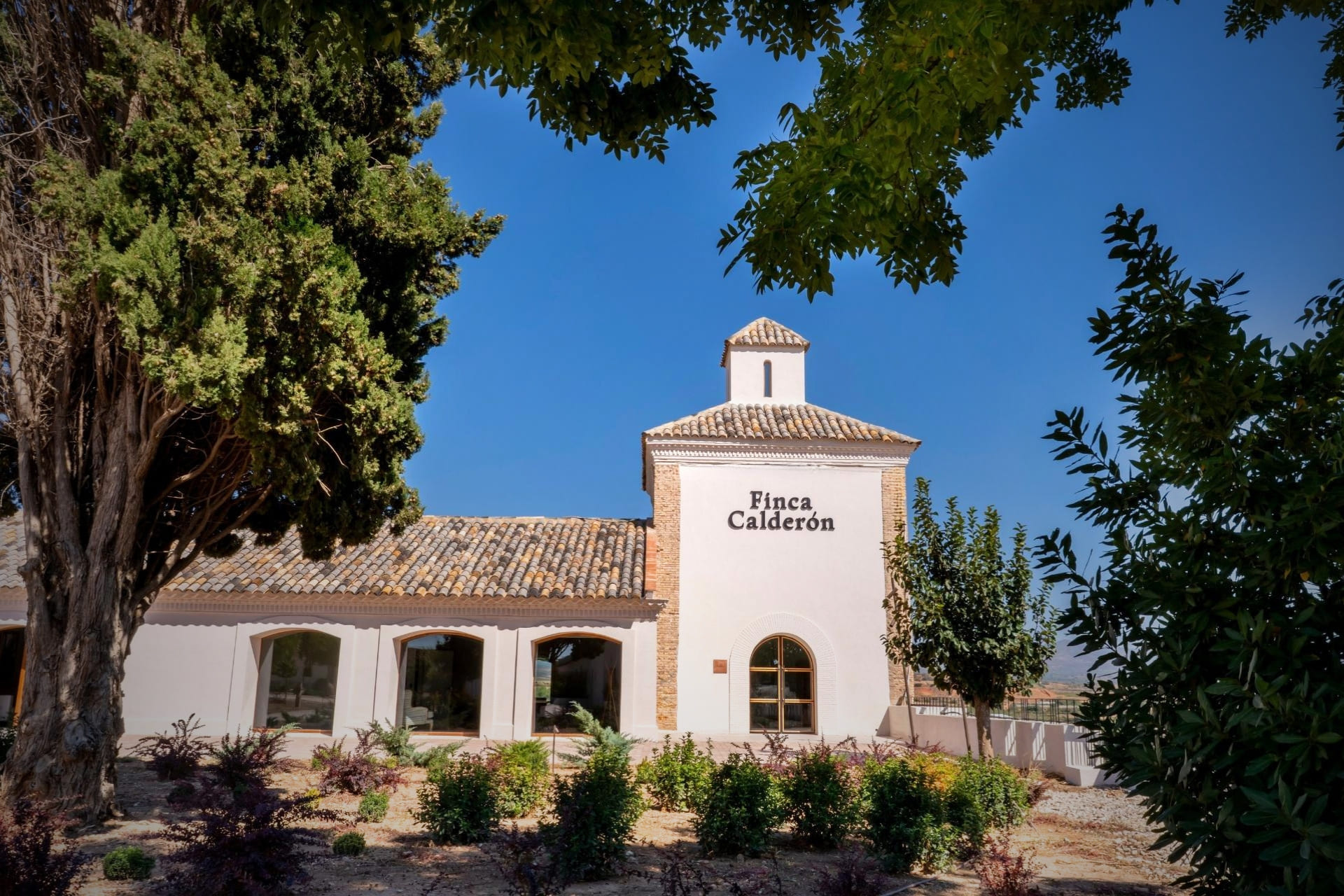 Vista frontal del edificio rehabilitado de Finca Calderón Enoresort, destacando su arquitectura del siglo XIX y su entorno natural en Requena.