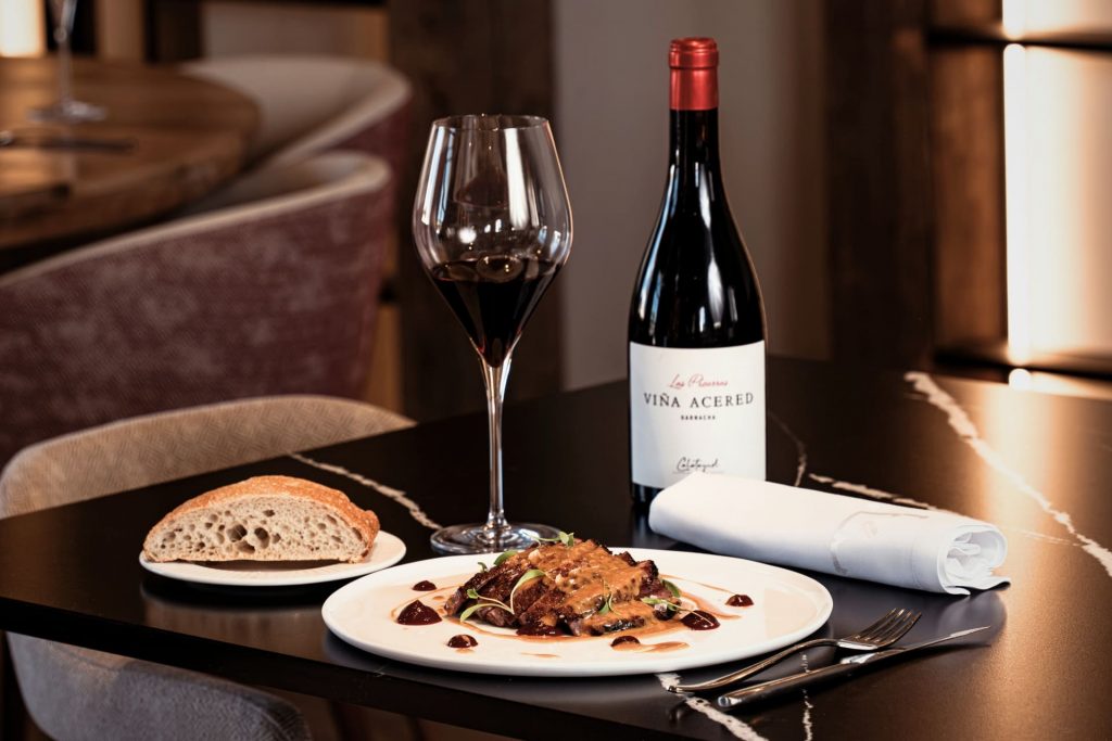 Mesa del restaurante de Finca Calderón preparada con platos de cocina de autor, copas de vino y cava ecológico, ideal para experiencias gastro únicas en Requena.