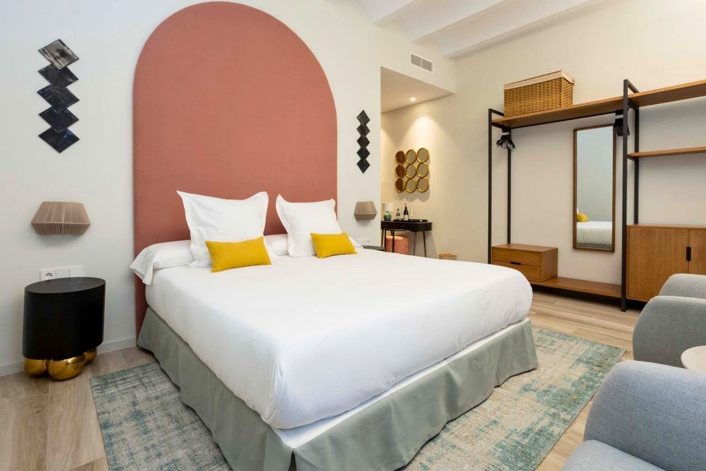 Spacious double suite at Hotel Finca Calderón, featuring a queen-size bed, a bottle of cava as a welcome gift, and a private terrace with panoramic views of the vineyards.